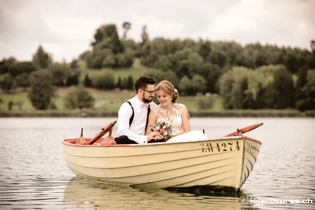 Hochzeitspaar Brautpaar Fotoshooting auf einer Hochzeitsreportage. Das Pärchen sitzt in einem Fischerboot