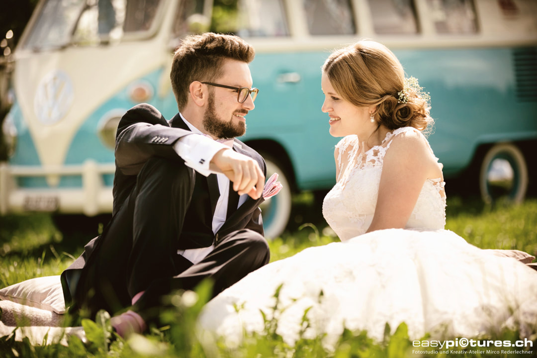 Hochzeitspaar Brautpaar Fotoshooting auf einer Hochzeitsreportage mit VW Bulli im Hintergrund